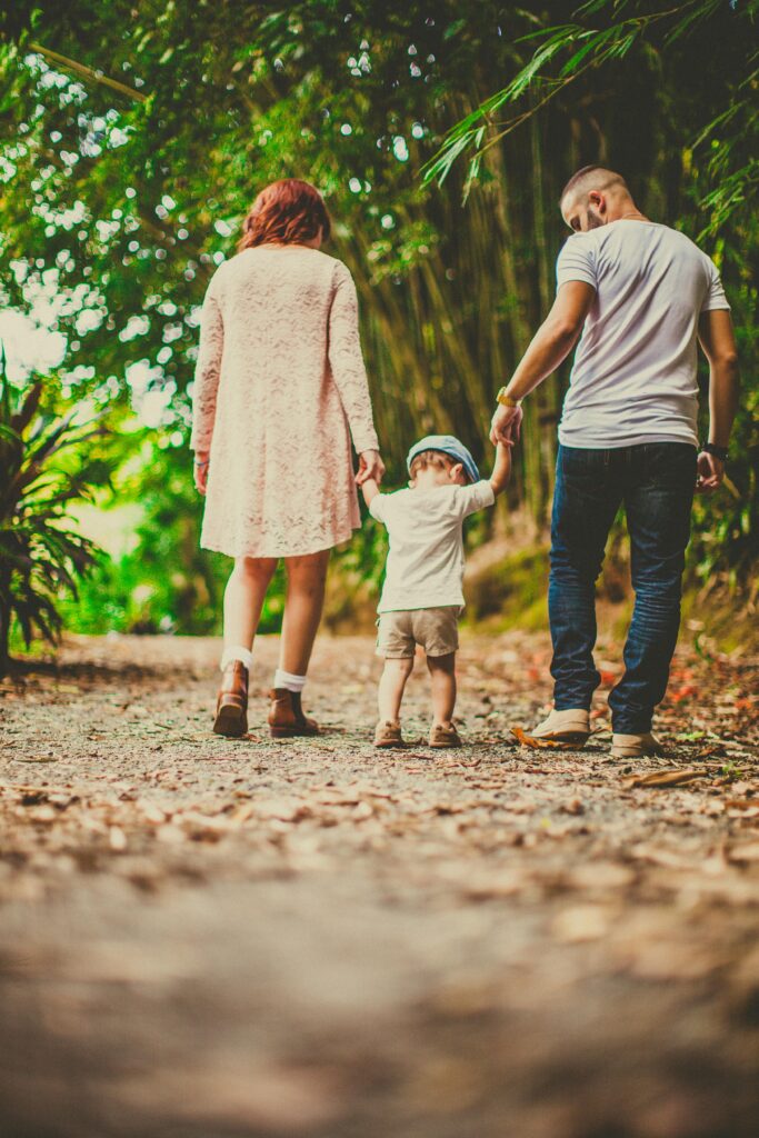 pexels-photo-3038455-3038455 A family enjoys a leisurely walk in a green park, embodying joy and togetherness.